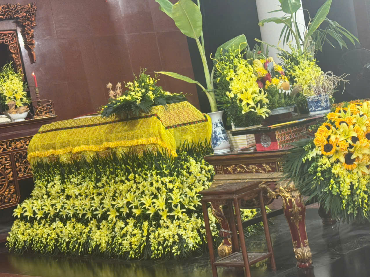 Bàn lễ, khung ảnh và phần hoa trong không gian tưởng niệm.